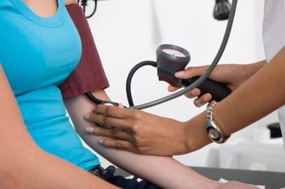 Femeie de vârstă mijlocie care stă liniștit pe canapea cu o ceașcă de ceai